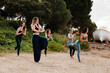 © Manu Reyes/Westend61 - Smiling female instructor practicing yoga with friends against plants