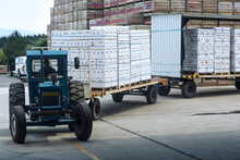 Tractor Transporting Produce In Boxes On Factory Yard