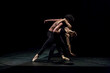 © Nadine Ginzel/Westend61 - Male and femal dancer performing contemporary ballet on black stage