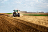 Fototapeta Las - Farmer in tractor plowing field in spring