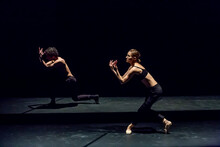 Male And Femal Dancer Performing Contemporary Ballet On Black Stage