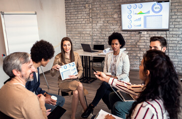 Group of diverse group of business people having a meeting while sitting in circle.