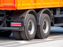 Dump Truck Wheels With All-season Tires On An Asphalt Road. A Close-up Of The Rear Axles Of A Truck. Construction Machinery In The City