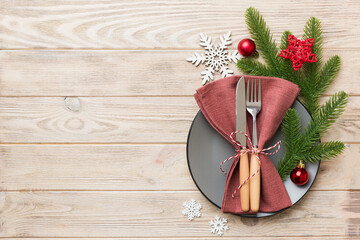 Christmas table place setting with christmas decor and plates, kine, fork and spoon. Christmas holiday background. Top view with copy space