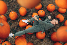 Beautiful Woman Lies In A Field On Pumpkins, Under The Rain Of Pumpkins.