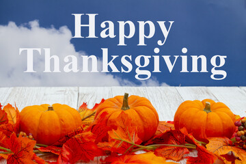Poster - Happy Thanksgiving greeting with fall leaves and pumpkins with sky