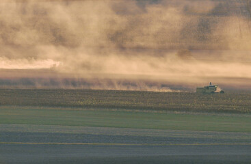 Poster - Agricultural field during harvest time with industrial combine machine in working prosses