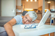 © Dragana Gordic - Mature businesswoman sleeping at workplace. Shot of a mature businesswoman falling asleep at her desk while working in an home office at night. Menopausal mature woman at work feels bad