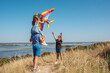© Andrii - Happy family with a child playing with a kite in nature