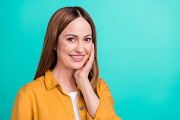 Wall Mural - Photo of cute pretty mature lady wear yellow shirt arm cheek applying cream smiling isolated turquoise color background