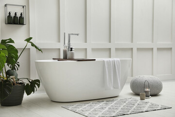 Wall Mural - Modern ceramic bathtub and green plant near white wall indoors