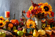 Thanksgiving Cornucopia Overflowing With Fruit Nuts Pumpkins Sunflowers Burning Candle And Bird Cage