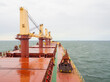 Dry bulk carrier ship with crane crab and towers at sea, deck view