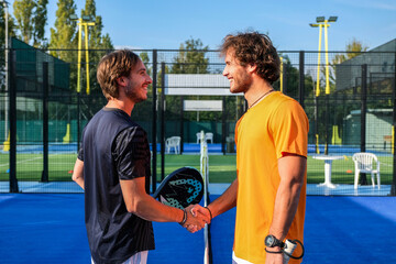 Wall Mural - Portrait of handshake of two padel tennis players - Padel players embracing after win a padel match