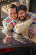 © ideasRojas  - Latin gay couple in a funny moment reflecting on a car roof, vertical frame.