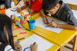 © SHUTTER DIN - Asian children hands holding colored pencils painting on art drawing paper in classroom at summer school