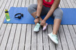 © Wavebreak Media - Midsection of african american plus size woman in sports clothes sitting on yoga mat and tying shoes
