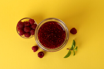 Wall Mural - Jar of raspberry jam with ingredients on yellow background