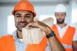 © fotofabrika - Two young men builders carrying wood planks on construction site, close up
