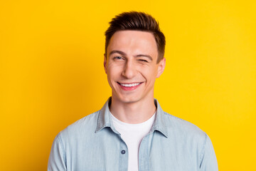 portrait of young attractive handsome flirty man wink blink eye romance expression isolated on yello