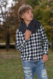 Fototapeta Młodzieżowe - Light-eyed blond boy enjoys autumn in a park. autumn clothes in white and plaid shirt, with gray scarf. torn jeans.