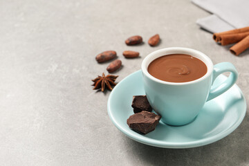 Yummy hot chocolate in cup on light grey table. Space for text