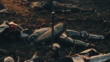 After Epic Battle Bodies Of Dead And Killed Medieval Knights Lying On Battlefield. Warrior Soldiers Fallen In Conflict, War, Conquest, Crusade. Cinematic Dramatic Historical Reenactment.