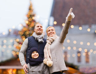 Poster - winter holidays, leisure and people concept - happy family over christmas market background