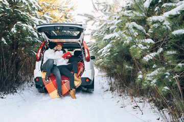 Wall Mural - lovely smiling couple sitting in car trunk