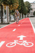 traffic, city transport and people concept - woman cycling along red bike lane with signs of bicycle on street in tallinn, estonia