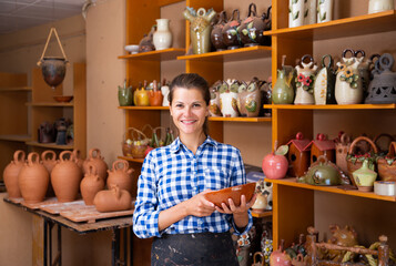 Wall Mural - Woman sells handmade pottery in a store. High quality photo