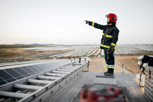 Fireman Standing On Roof Of Truck