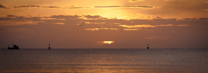 Red purple orange blue pink sunsets over sea and Burning sky and shining golden waves.Sun over sea silhouette paradise island.