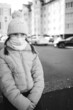 © Анна Молько - sad girl in a yellow jacket and medical mask sits on a concrete slab on the background of the autumn city. black and white photo