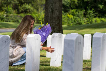 A Grieving Woman Shares Her Emotions With Her Fallen Veteran Family Member At A MIlitary Cemetery