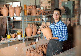 Wall Mural - Woman chooses pots clay pots in store warehouse. High quality photo