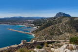 Fototapeta  - View of the blue mediterranean sea and a port of a coastal city and a beautiful mountain landscape in Spain