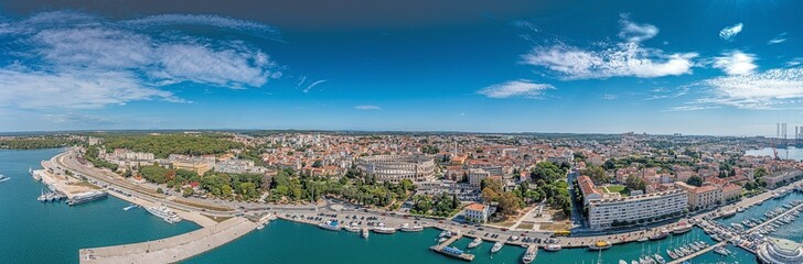 Drone panorama of the Croatian coastal city of Pula taken during the day above the harbor