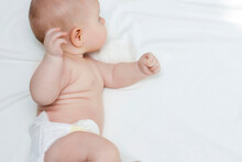 The Skill Of Turning From The Back To The Stomach. The Baby Learns To Roll Over. A Newborn.