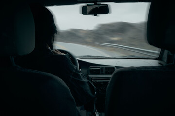 Poster - Back view of a Bolivian man driving his car in the countryside