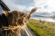 © Pietro Karras/Stocksy - Anonymous woman leaning out from car window in nature
