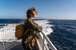 © Pietro Karras/Stocksy - Dreamy female standing on deck in wind