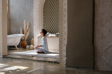 Woman Meditating In Oriental Bathroom
