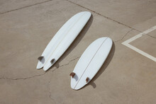 Two White Surf Boards On Concrete
