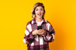 © luismolinero - Young Russian woman isolated on yellow background surprised and sending a message