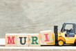 Toy forklift hold letter block i to complete word muri on wood background
