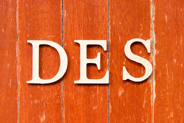 Sticker - Alphabet letter in word DES (Abbreviation of Delivered Ex Ship) on old red color wood plate background