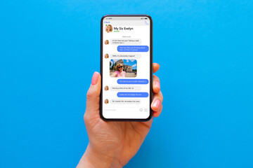 Woman using messaging app on her phone, mockup of sample chat application interface on blue background
