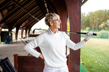Portrait Of Female Senior Golf Player Looking At The Ball After Taking A Swing.