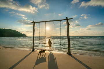 Silhouette of traveler women standing beside coconut trees watching the sunrise paradise beach on Phu Quoc island, Vietnam